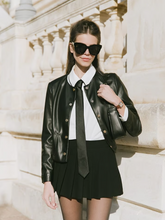 a lady wears a white shirt with a black leather jacket and a mini skirt